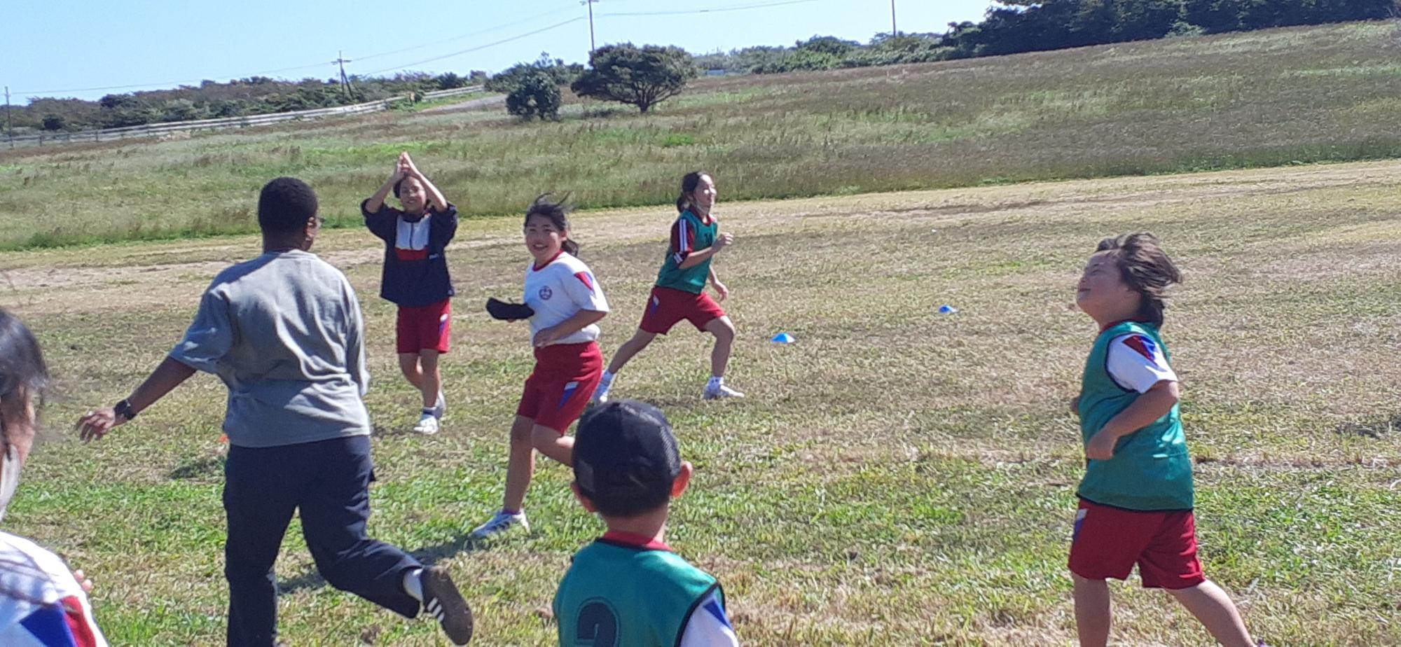 校庭で児童たちが元気にボール遊びをしている写真