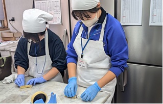 調理実習で作業する生徒たちの写真
