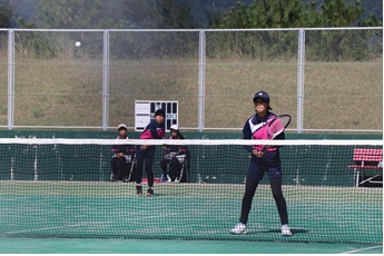 テニスの試合をプレーしている女子生徒二人の写真