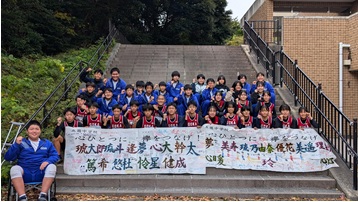 階段で横断幕を掲げて記念撮影をしている生徒たちの写真