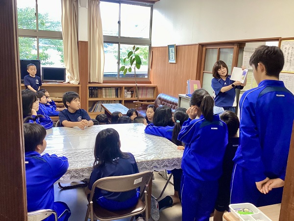 図書室で先生が児童たちに本の読み聞かせや説明をしている写真