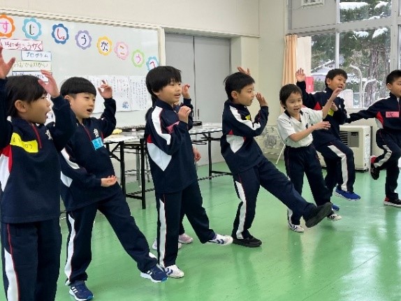 教室で児童たちが体を動かして発表している写真