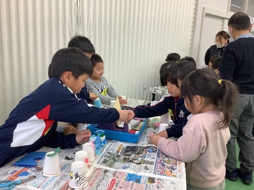 教室で児童たちが一緒に工作をしている写真