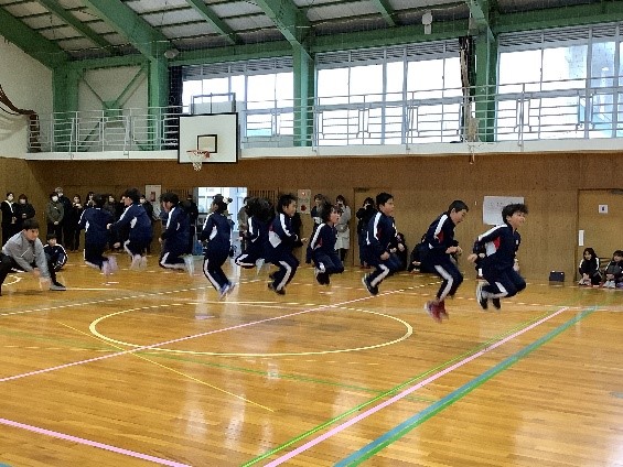 体育館で児童たちが大縄跳びをしている写真