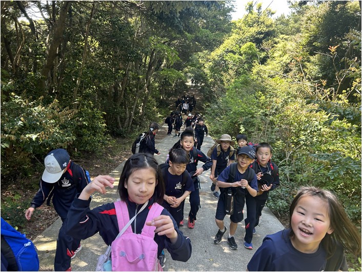 山道を登る子どもたちが楽しそうに歩いている写真