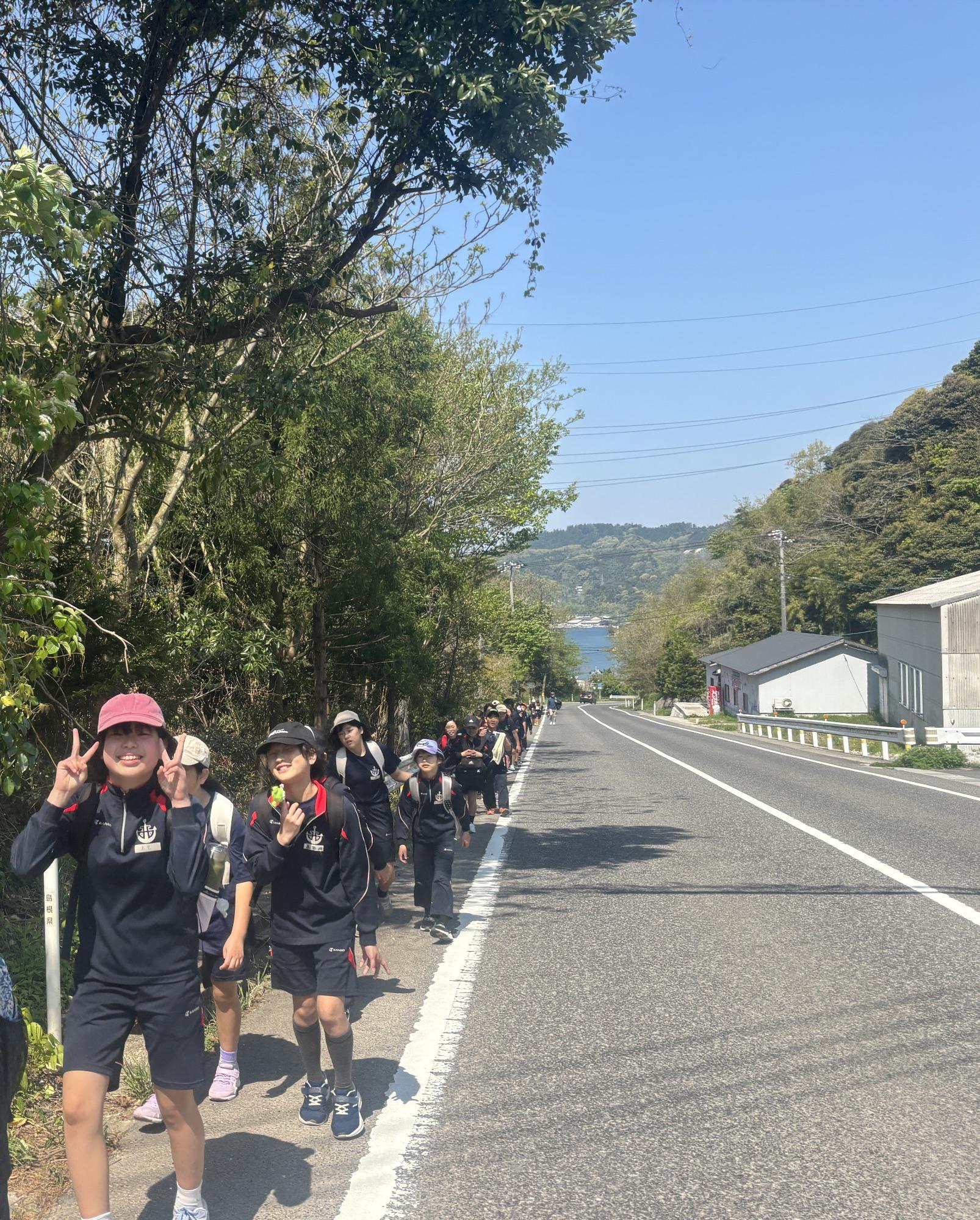 並木道を子どもたちが列になって歩いている写真
