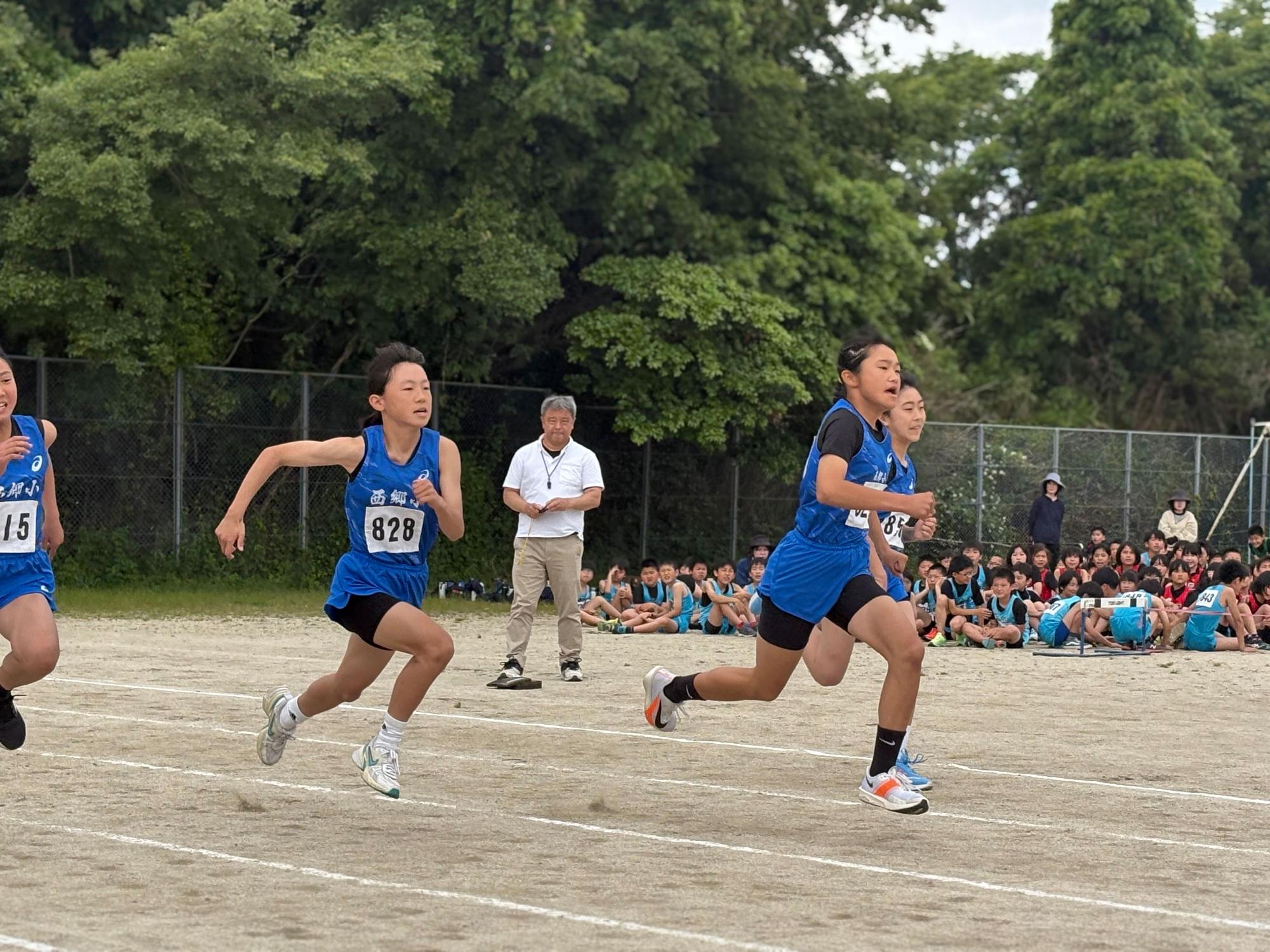 陸上競技で女子が力強く走っている写真