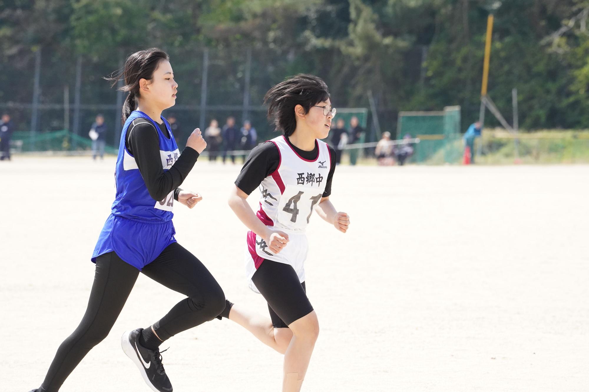 グラウンドで女子生徒二人が並んで走っている写真