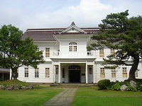 洋風の外観で白い壁と赤い瓦屋根の旧周吉外三郡役所庁舎の写真