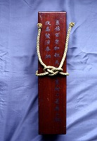 紐で括られて文字の書かれた箱に収められた紙本墨書高田明神百首和歌の写真
