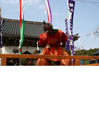 面と煌びやかな赤い服装で行われている隠岐国分寺蓮華会舞の写真