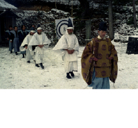 雪が積もっている中、射的の的が置いてあり3種類の服装の人々が歩いている山田客祭風流の写真
