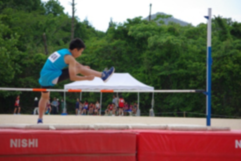 走り高跳びのバーを足を開いて飛び越えている児童の写真