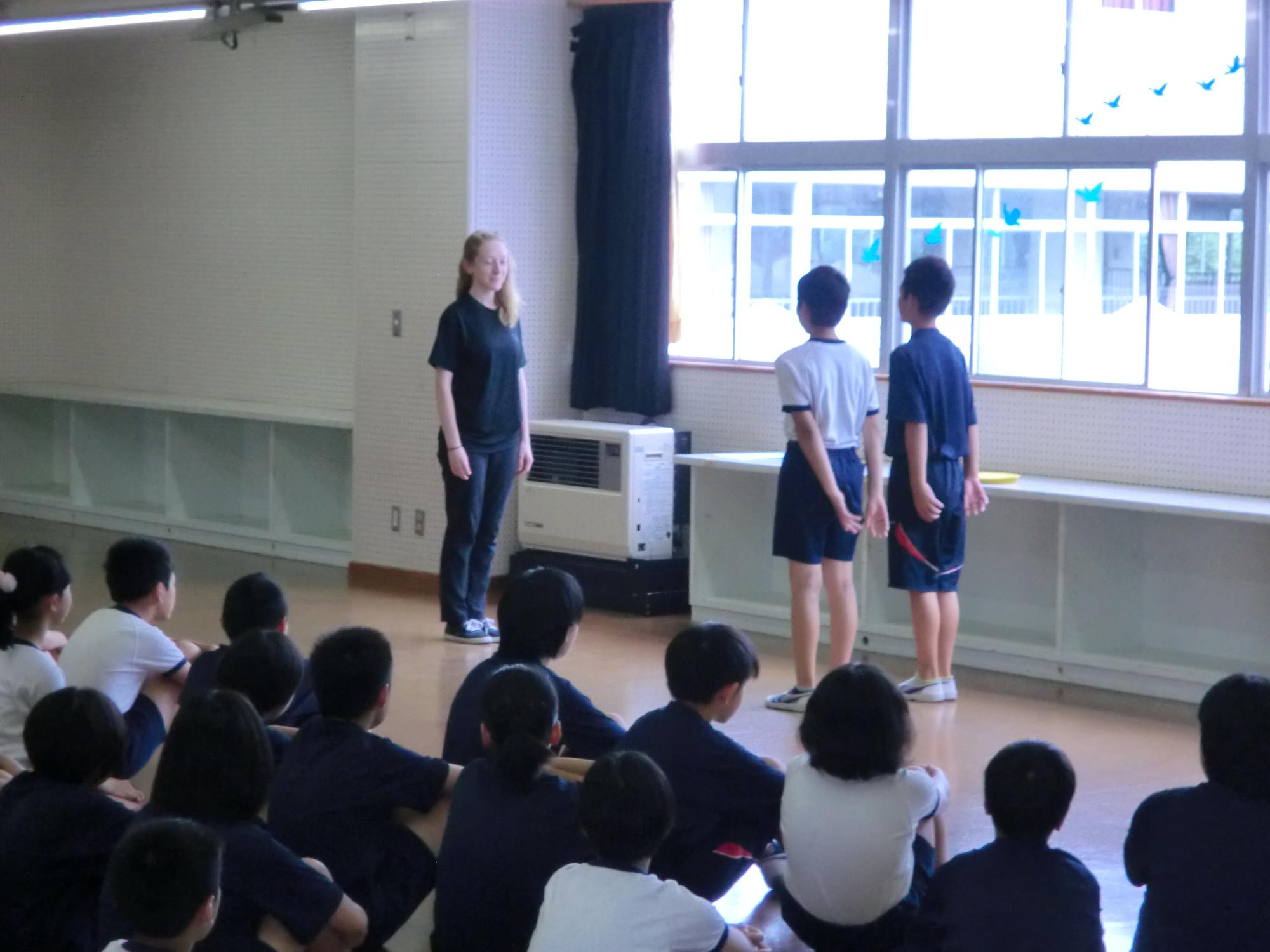 レイチェル先生と向かい合って立っている2人の児童の写真