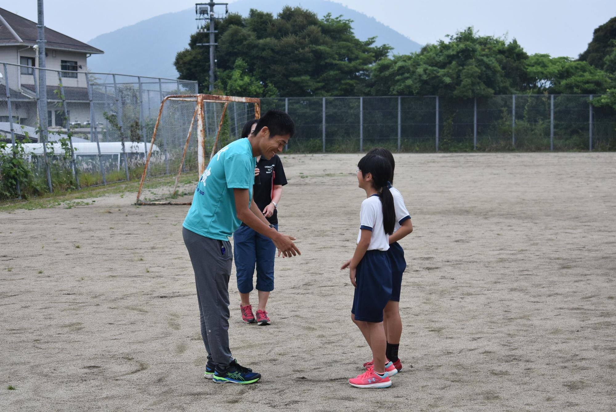 校庭で川内選手と話をしている児童の写真