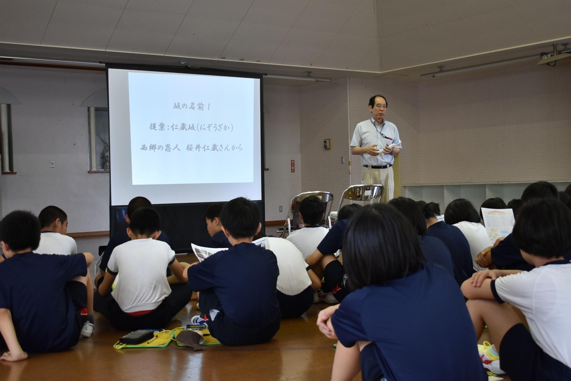 床に座ってスライドを見ている児童たちの写真