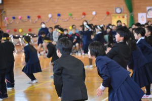 飾り付けがされた体育館で複数の児童が体を動かしている写真