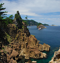 日本海の荒波に浸食されて奇岩怪石がそびえ立つ断崖絶壁の海岸線の写真
