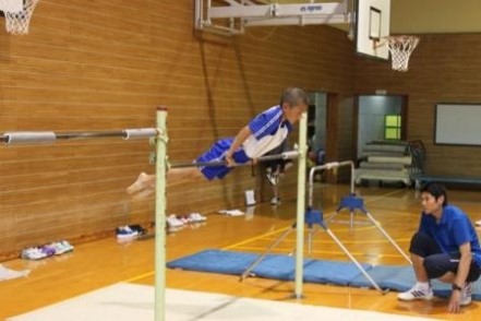 児童が屋内で鉄棒をしている写真