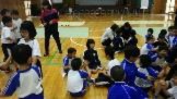 体育館で児童たちが輪になりゲームをしている写真