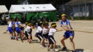 校庭で児童たちが綱引きをしている写真