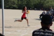 運動場で児童がゴールに向かって走っている写真