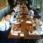 長机で児童たちが食事を楽しんでいる写真