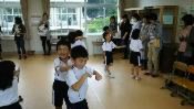 教室で児童たちが体を動かして遊んでいる写真