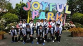 遊園地の入り口前で児童たちが並んでいる記念撮影の写真