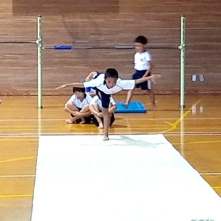 マットの上で片足立ちになりバランスをとっている児童の写真