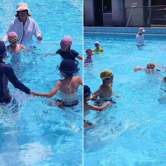 プールで手をつないで輪になって遊んでいる児童たちの写真