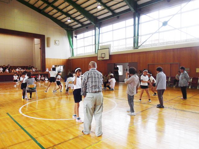 体育館で児童が保護者や地域の方々とペアになって向き合っている写真