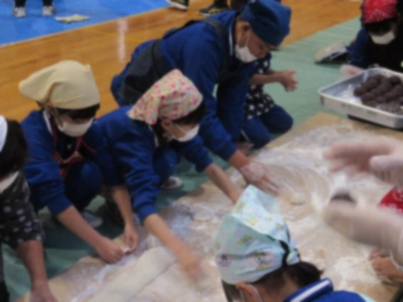 児童たちが敷物に並べらてたついた餅の形を整えている写真