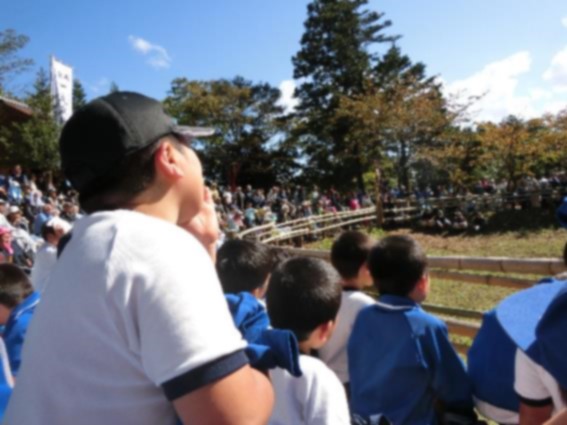 観客席から口元に手を当てて応援している児童の写真