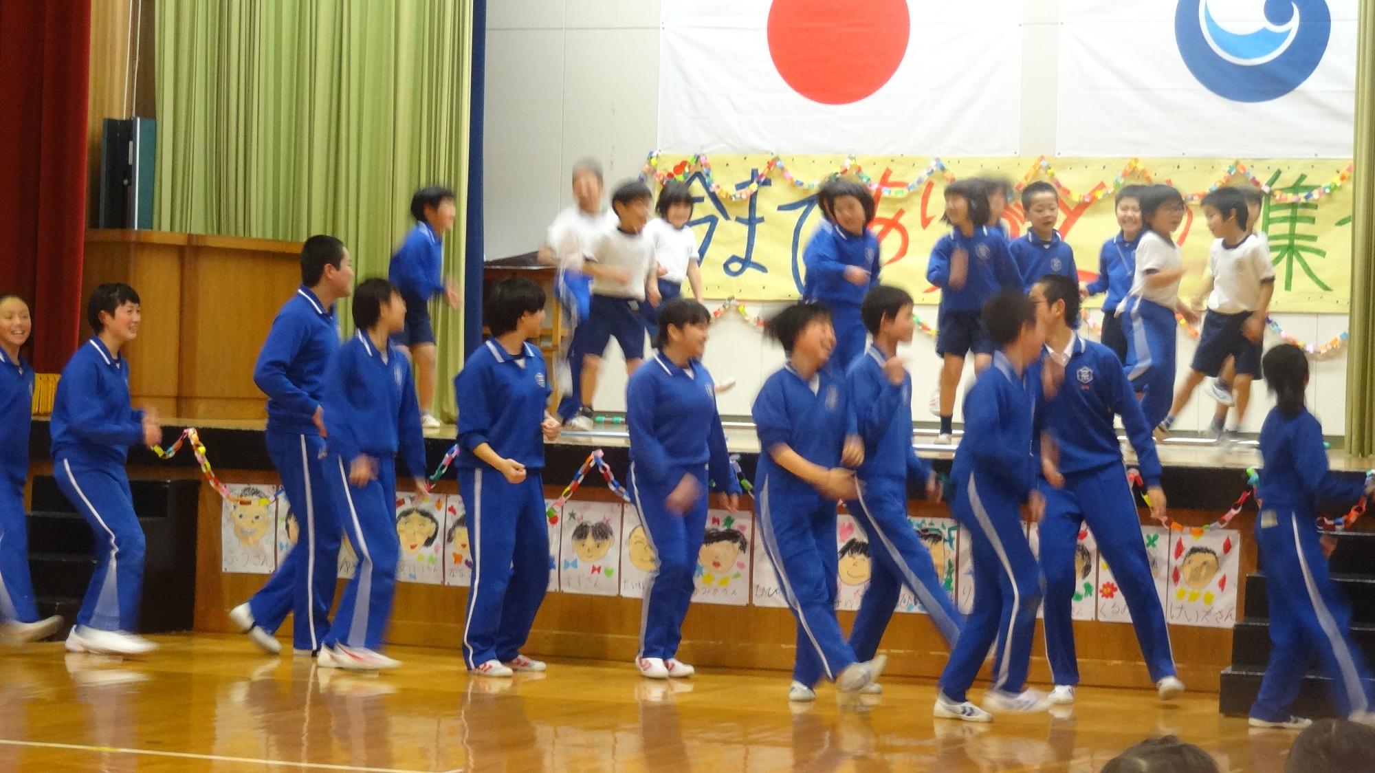 体育館で下級生の児童たちが出し物を演じている写真