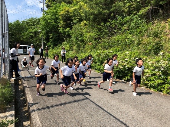 体操着姿の児童たちが一斉に走り出している写真