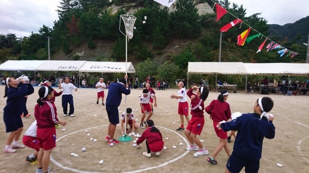 校庭で児童が玉入れをしている写真