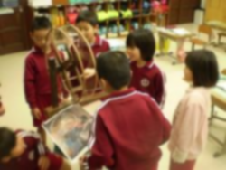 教室で児童たちが抽選機を囲んでいる写真