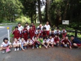 道路わきの空き地で記念撮影をしている児童たちの写真