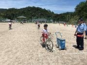 自転車に乗った姿勢で指導員の話を聞く児童の写真