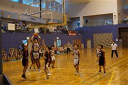 体育館で児童たちがバスケットボールの試合をしゴールを打っている写真