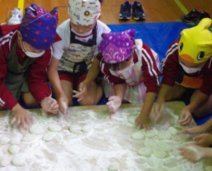 子どもたちが手で丸めて餅を作っている画像