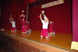 下級生の児童がステージで小道具を使い出し物をしている写真