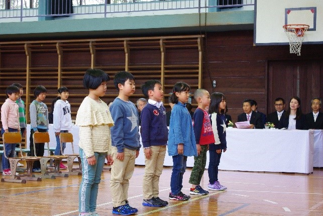 体育館で児童たちが横に整列している写真