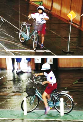 ヘルメットをかぶり自転車から降りて押していたり、自転車に乗っている児童の写真