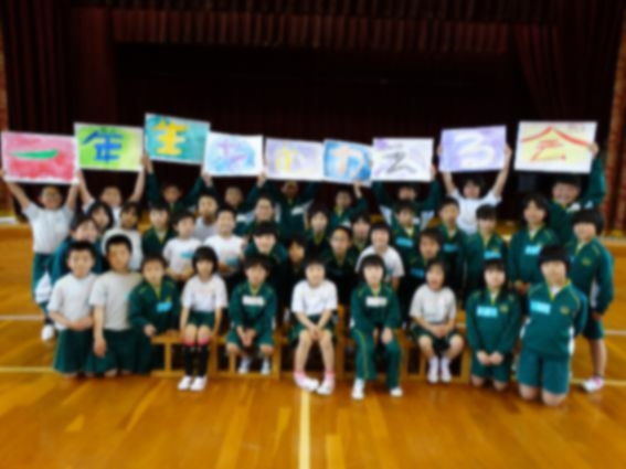 一年生を歓迎する絵を掲げた児童たちと記念撮影している写真