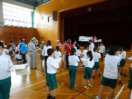 体育館で交通安全のクイズに参加している児童たちの写真