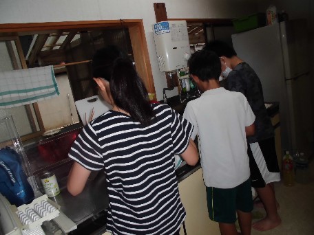 合宿上の台所で数人の児童が並んで作業している写真