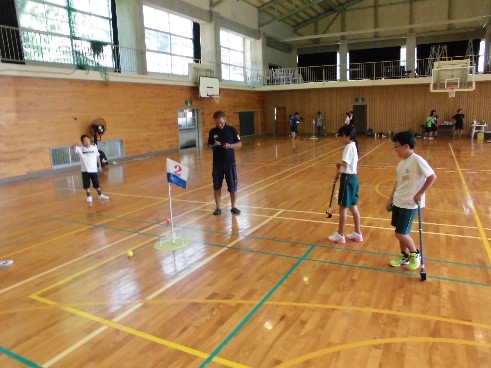 体育館で児童たちがグランドゴルフをしている写真