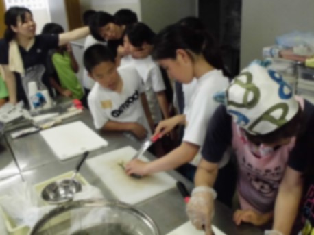 児童たちが調理台で魚をさばいている画像